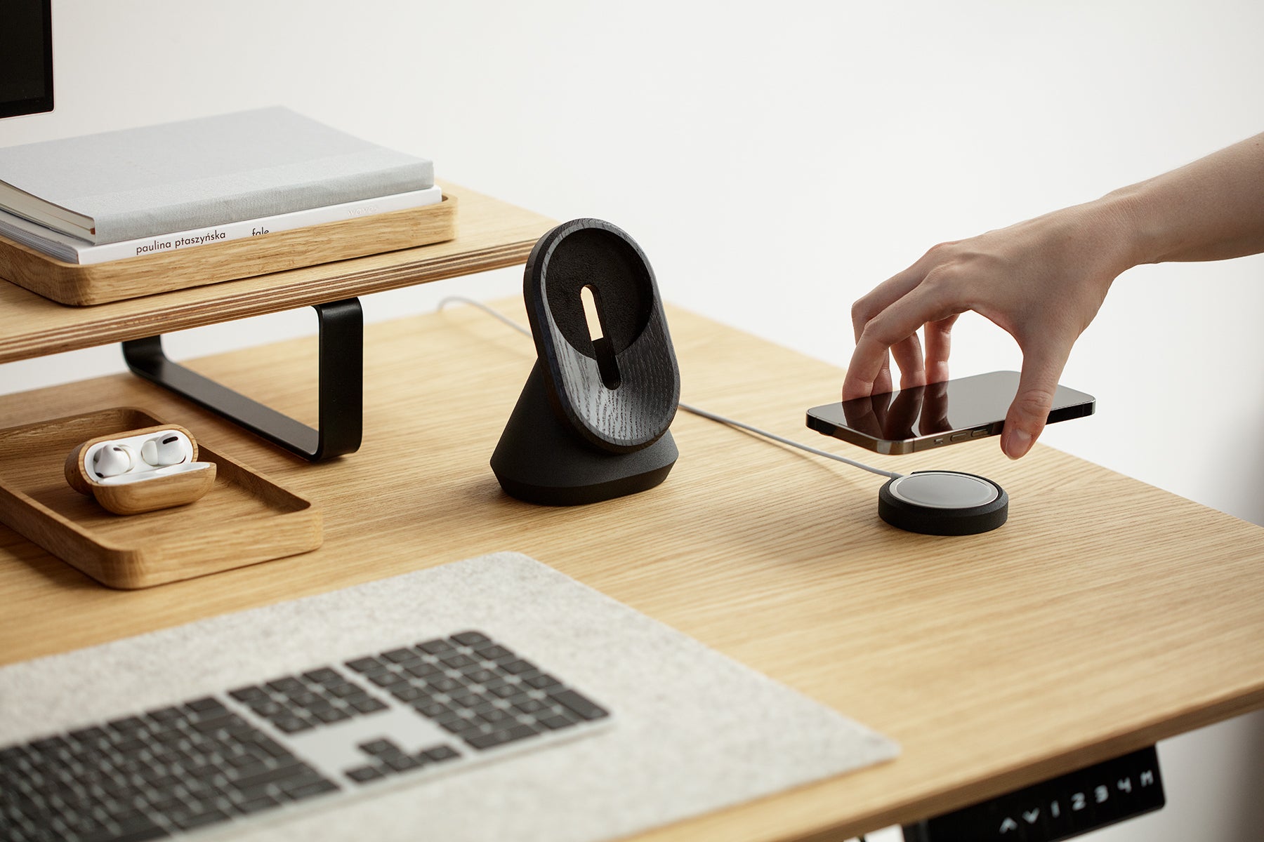 black magsafe iphone stand on a wooden standing desk | -