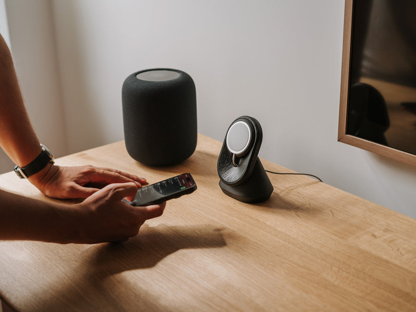 black magsafe iphone mount on a oak wooden desk with spotify music and homepod music center | -